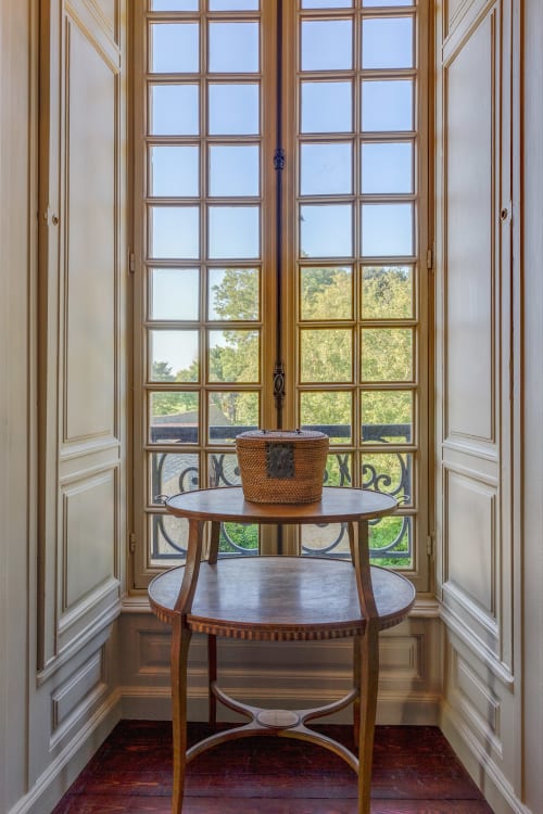 Elegant balcony room at Château d'Alexis de Tocqueville with period doors, round wooden table, and views of French