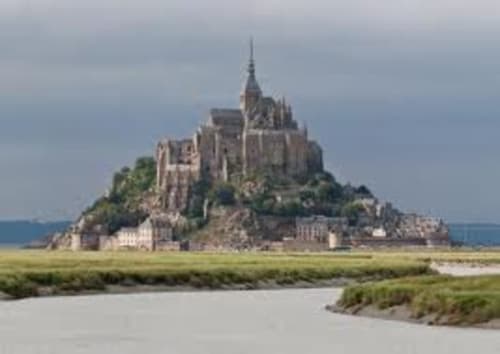 Mont-Saint-Michel castle perched on rocky island surrounded by tidal flats and waterways in Normandy