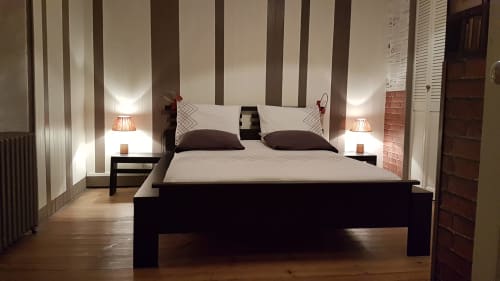 Chambre moderne à L'escale Marine B&B à La Rochelle avec lit noir, tête de lit rayée, lampes de chevet et parquet
