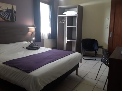 Spacieuse chambre familiale du Relais Motel de Maisonnay avec lit queen, armoire, bureau et fauteuil