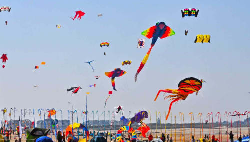 Coloridas cometas volando en el festival de playa de Houlgate, Francia cerca del hotel Les Cabines