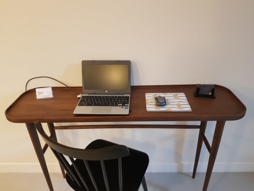 Wooden desk workspace at Hotel Au Bon Coin in Biarritz with laptop, notebook, and chair
