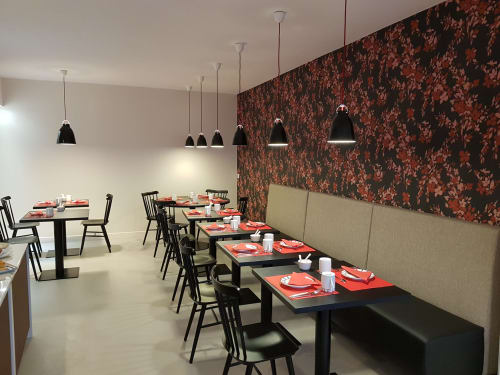 Modern restaurant dining area at Hotel Au Bon Coin in Biarritz with black tables, red place settings, pendant lights, and