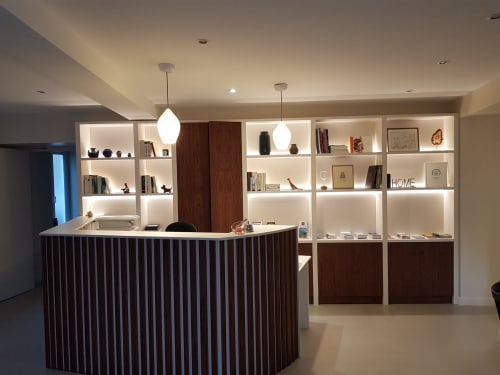 Modern hotel reception desk at Hotel Au Bon Coin in Biarritz with illuminated shelving and contemporary design