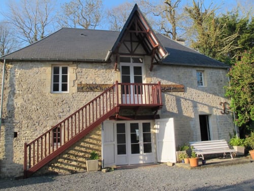 Stone cottage with red staircase at Chateau d'Asnieres en Bessin, France