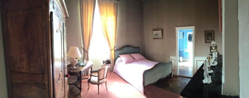 Elegant bedroom at Chateau d'Asnieres en Bessin B&B with garden view, pink bedding, period furniture, and natural light