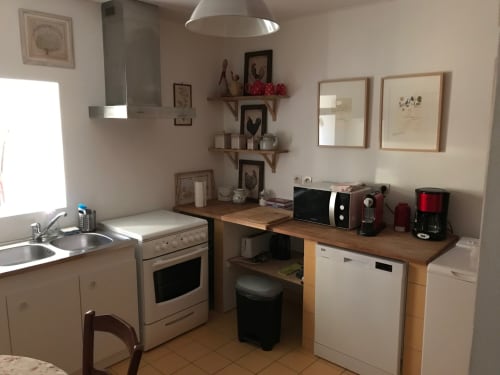Compact kitchen with stove, microwave, dishwasher, and counter space at Chateau d'Asnieres en Bessin cottage