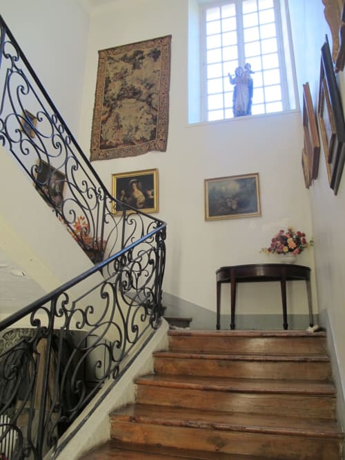 Elegant staircase with wrought iron railings at Chateau d'Asnieres en Bessin, French country manor with historic artwork and