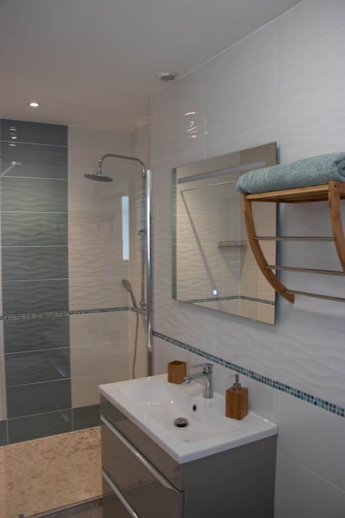 Modern bathroom in Room Saona at Belloréade B&B with walk-in shower, white sink, and towel rack