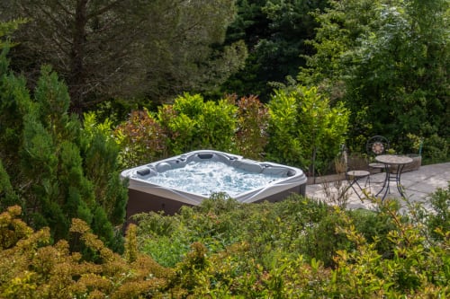 Hot tub with bubbling water nestled in lush garden at Belloréade B&B, Belloc