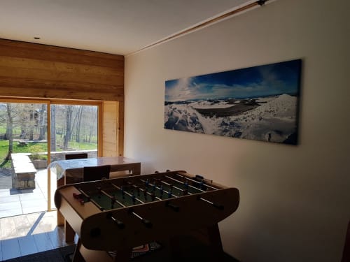 Salle de jeux dans un gîte français avec baby-foot, art paysager, mur en bois et portes vitrées sur le parc