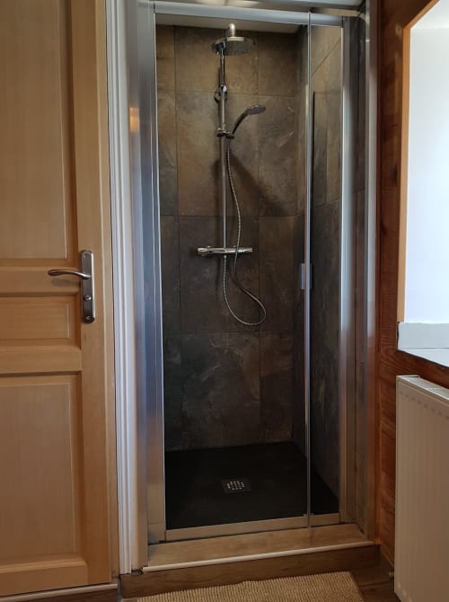 Douche moderne aux parois vitrées, carrelage sombre et pomme de douche pluie dans la Chambre double d'Aux Pays Des Sucs