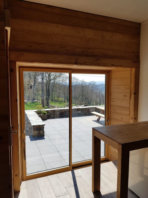 Chambre double avec portes en bois ouvrant sur une terrasse avec vue sur les montagnes aux Pays Des Sucs, Saint-Hostien