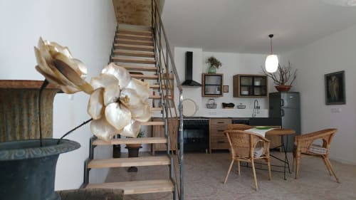 Open-plan kitchen and dining area in Mazet 1 cottage at Mas des Artistes, Mouriès, with wooden stairs, rattan chairs, and