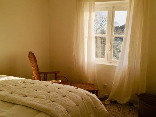 Bright bedroom at Saint Martin B&B in Ollioules with yellow walls, white bedding, wooden chair, and window overlooking