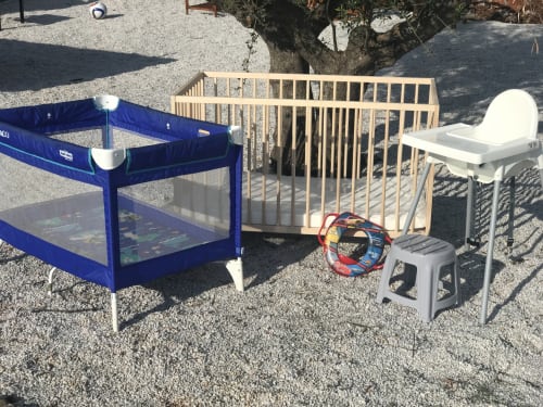 Baby gear collection at Villa Freedom in Kokkino Chorio, Crete including playpen, crib, and high chair