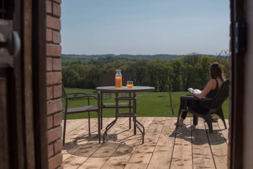 Femme se détendant sur la terrasse du gîte Le Pignié avec vue sur la campagne, Lescure-d'Albigeois, France
