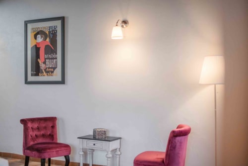 Chambre Aristide Bruant du B&B Le Pignié avec fauteuils en velours rouge, luminaire suspendu et affiche vintage française