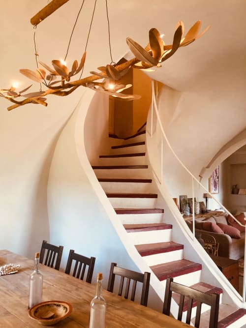 Sculptural wooden chandelier above dining area with staircase at Saint Martin B&B in Ollioules, France