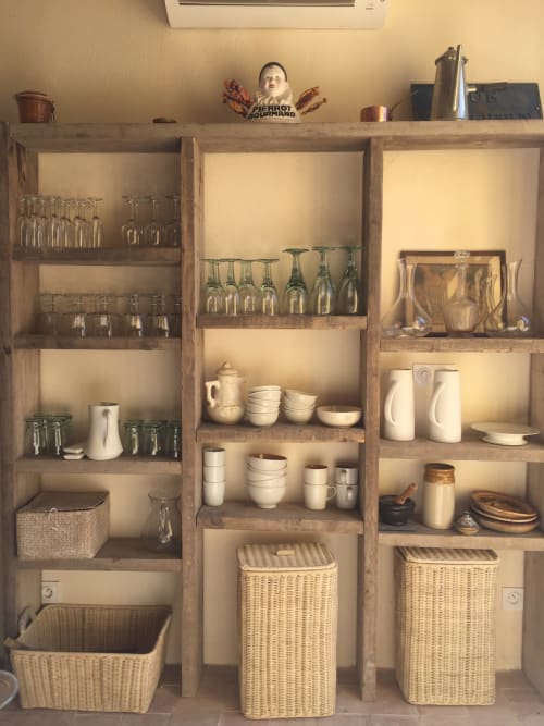 Étagère rustique en bois à la Maison d'hôtes Saint Martin à Ollioules présentant verrerie, céramiques et paniers en osier