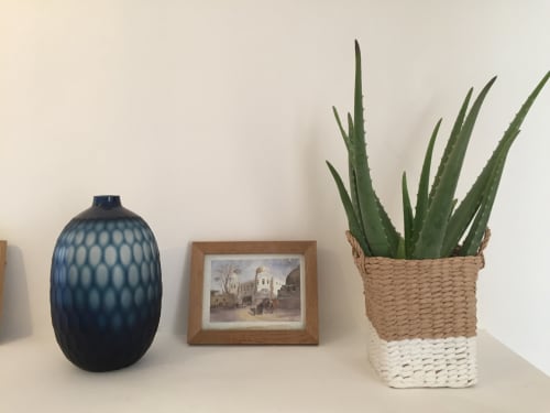 Decorative shelf display at Saint Martin B&B Ollioules with blue vase, framed artwork, and potted succulent plant