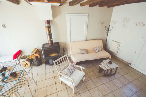Coin salon douillet aux gîtes des châteaux à Vallières-les-Grandes avec cheminée, canapé, fauteuils et style rustique