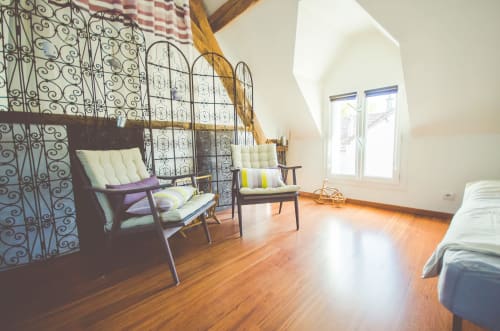 Chambre lumineuse au Gîte Angkor avec parquet, coin salon et lit en fer forgé à Vallières-les-Grandes