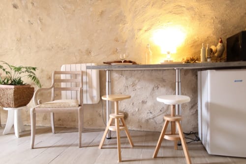 Kitchenette lumineuse aux murs en pierre rustique, coin bar et électroménagers modernes aux gîtes des châteaux
