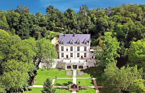 Élégant château blanc au toit mansardé entouré de jardins luxuriants et de boisés à Vallières-les-Grandes