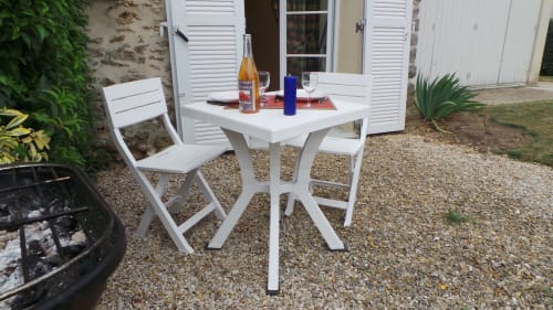 Table et chaises bistro blanches sur terrasse en gravier à La Croix De La Jarrie, Châtres avec vue sur jardin et mobilier d'été