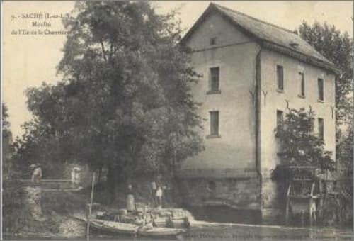 Moulin historique de la Chevrière à Saché, France avec architecture en pierre et verdure luxuriante