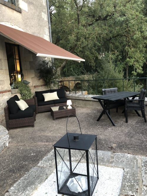 Outdoor patio at Moulin De La Chevrière with seating, dining table, and awning in Saché, France
