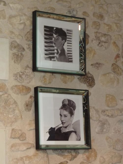 Deux portraits en noir et blanc encadrés sur un mur motifs à l'hôtel-boutique Moulin De La Chevrière à Saché, France