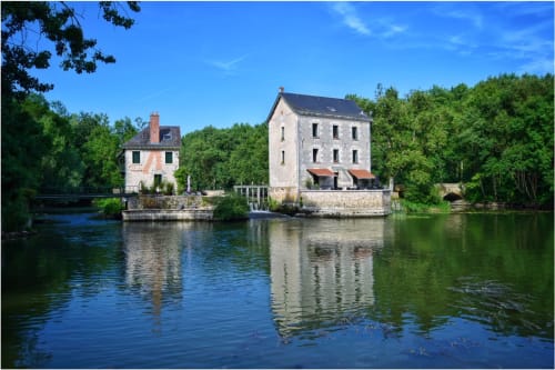Le moulin-hôtel Moulin De La Chevrière se reflète dans la rivière paisible de Saché, France, entouré de verdure