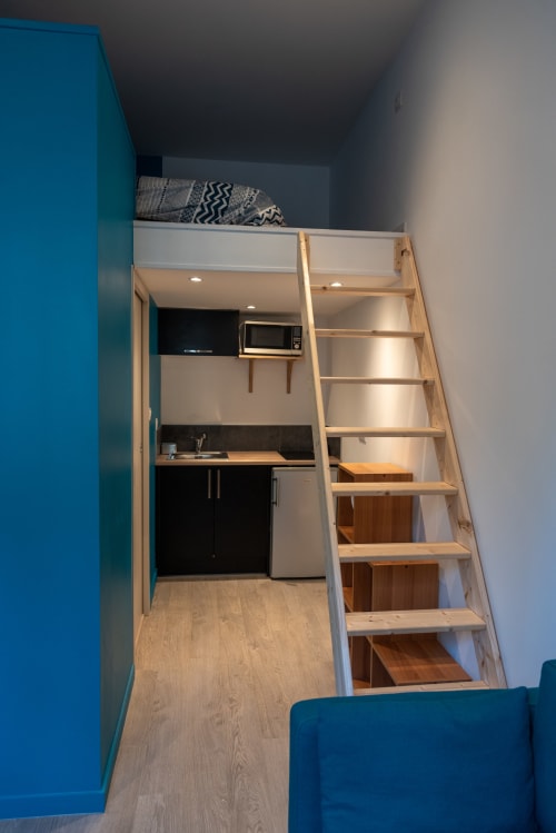 Loft Studio Hikoki à Dinan avec kitchenette, lit mezzanine en bois et murs bleu acier