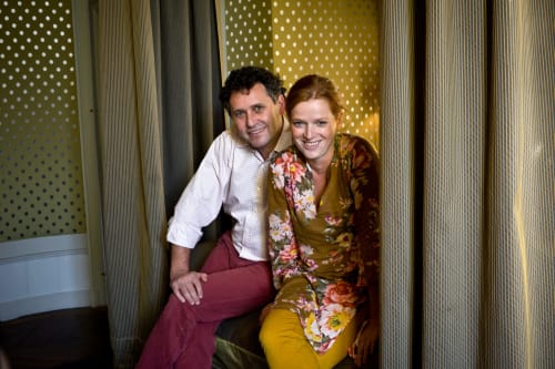 Couple souriant au gîte Saint Martin à Ollioules, France, assis ensemble dans un espace intérieur lumineux aux motifs à pois.