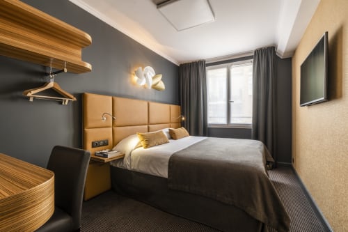 Modern Comfort Room at Hotel Residence Europe & Spa in Clichy with tan headboard, wood accents, and contemporary design