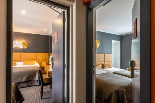 Connecting hotel rooms at Residence Europe & Spa in Clichy with modern furnishings and open doorways