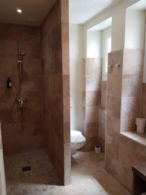 Salle de bains moderne avec douche à l'italienne, toilettes et lavabo à l'Hôtel Au Bon Coin à Biarritz