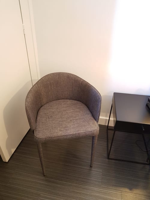 Chaise moderne en tissu gris dans la chambre triple de l'Hôtel Au Bon Coin à Biarritz, parquet foncé et bureau visible