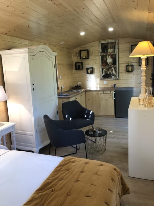 Chambre douillette en caravane au Moulin De La Chevrière avec kitchenette, coin salon et intérieur en bois
