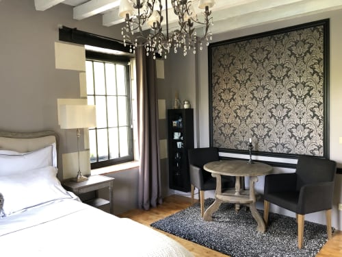 Chambre élégante au Moulin De La Chevrière avec papier damassé, lustre et mobilier contemporain