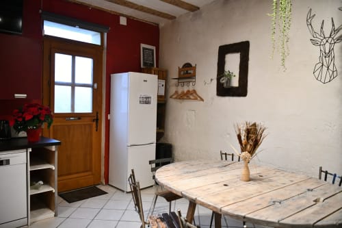 Coin repas chaleureux du gîte Le troglo du boy'fini aux Gîtes des châteaux, Vallières-les-Grandes, avec table en bois