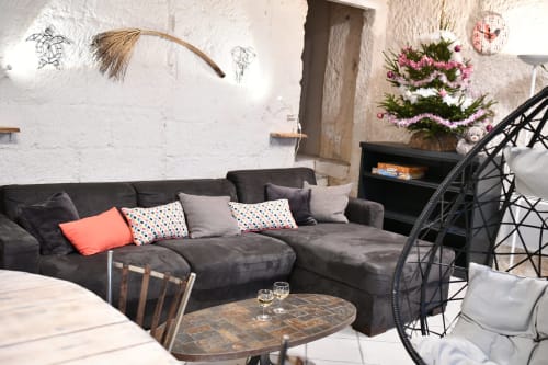 Salon contemporain du gîte troglodytique Les gîtes des châteaux à Vallières-les-Grandes, avec canapé gris et coussins décorés