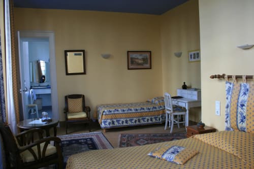 Superior room at La Chatellenie B&B in Saint Aubin le Cauf with twin beds, desk, sitting area, yellow walls and garden view