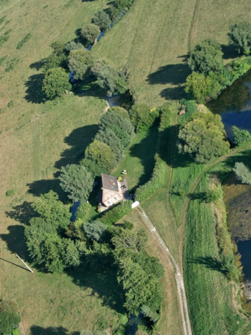 Vue aérienne du gîte La Bouverie à La Chatellenie à Saint Aubin le Cauf, entouré d'arbres et de rivière