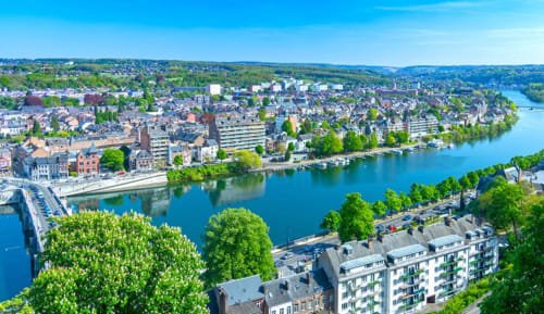 Vue aérienne de Dinant le long de la Meuse avec architecture historique et verdure luxuriante en Belgique