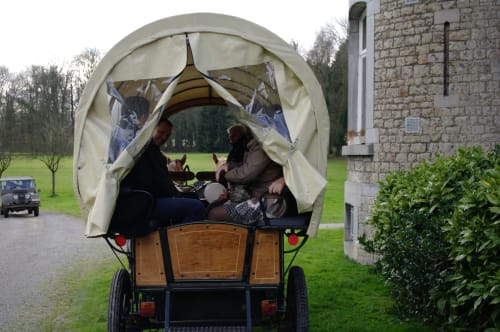 Two guests enjoying a traditional horse-drawn carriage at Château d'Hassonville B&B in Marche-en-Famenne, Belgium