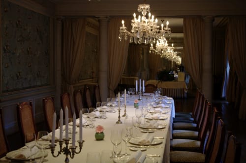 Elegantes formales Esszimmer von Château d'Hassonville mit Kristalllüster, langem weißem Tisch und feinen Gedeck