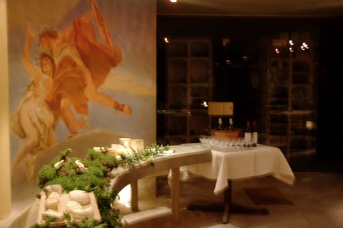 Élégante salle à manger du Château d'Hassonville avec œuvres d'art classiques, table illuminée à la chandelle et verrerie fine à Marche-en-Famenne